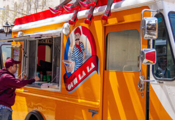 male customer ordering food from a yellow food truck