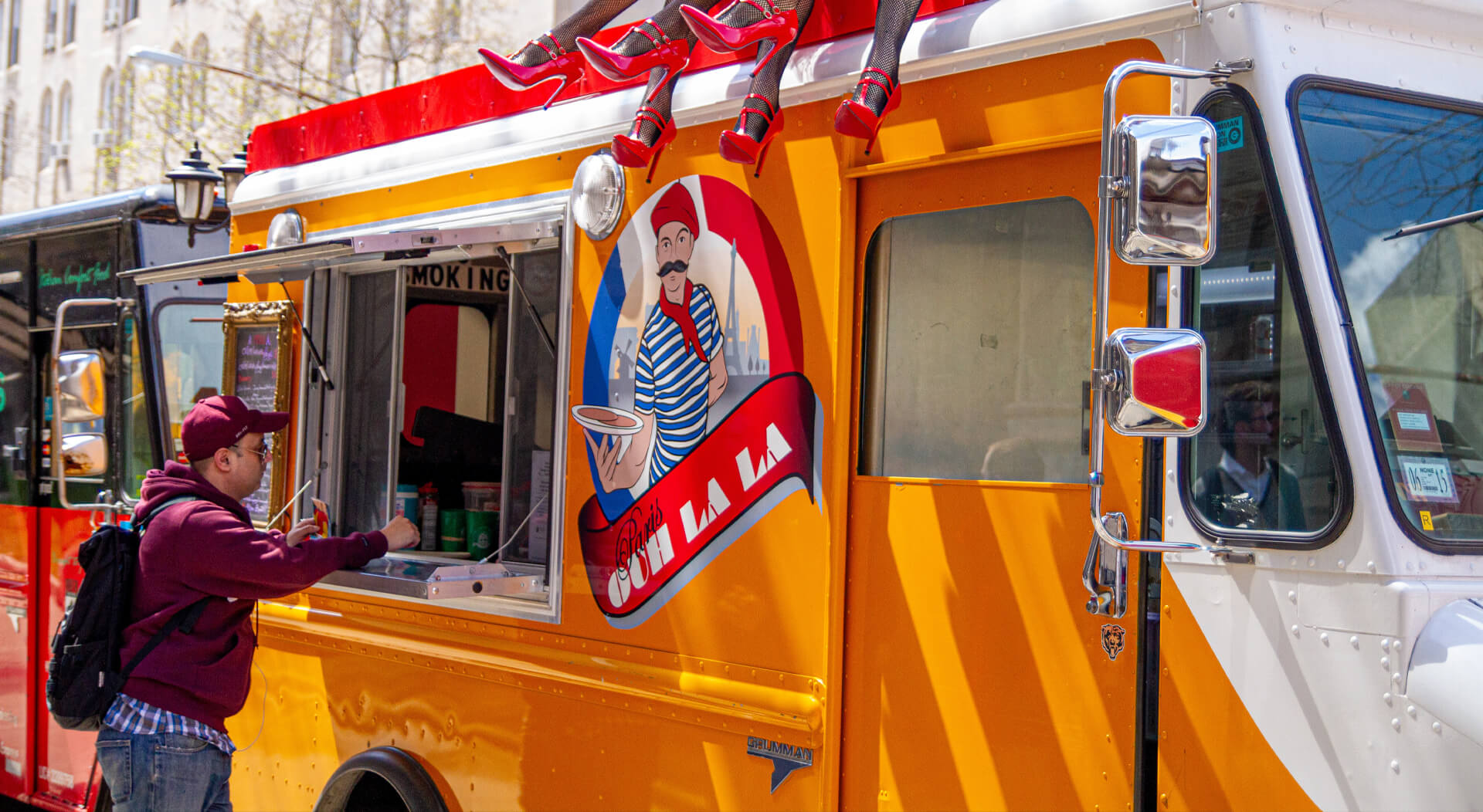 male customer ordering food from a yellow food truck