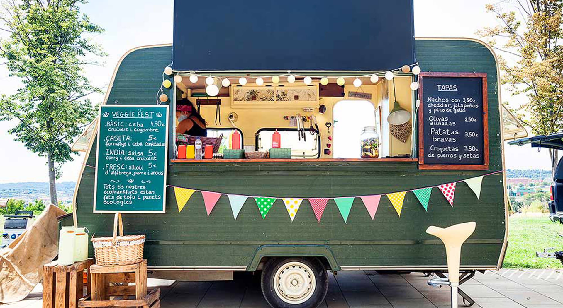 green food truck parked in a sunny park