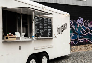 white concession trailer used as a food truck near a graffiti wall