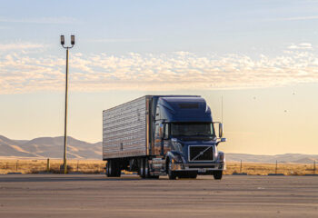 blue semi truck driven in a deserted road