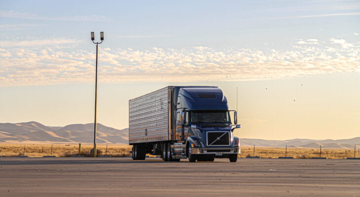 blue semi truck driven in a deserted road