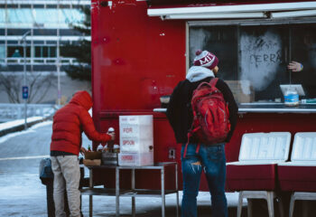 two persons at a food truck during winter