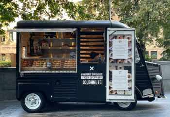 black mini donut food truck at the side of the road