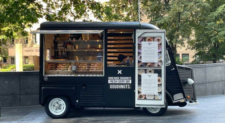 black mini donut food truck at the side of the road
