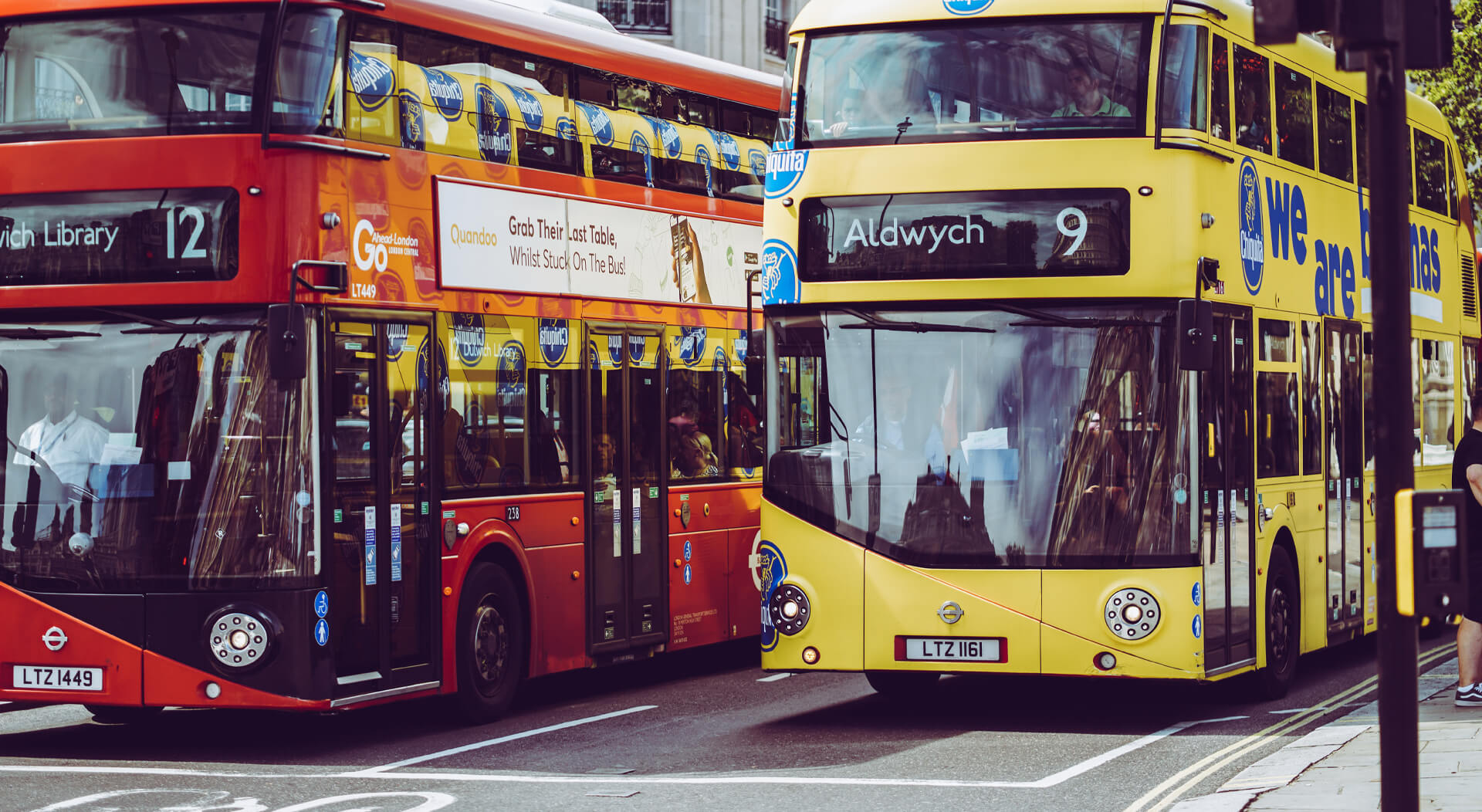 two double decker buses at a busy intersection