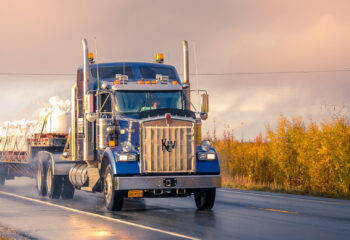 blue semi truck on the road during sunset