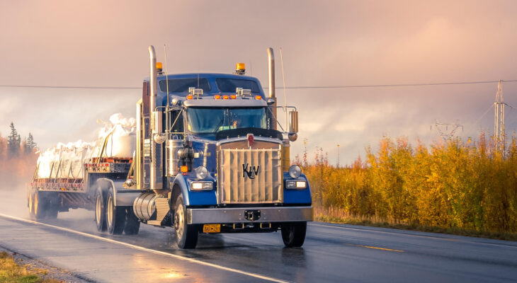 blue semi truck on the road during sunset