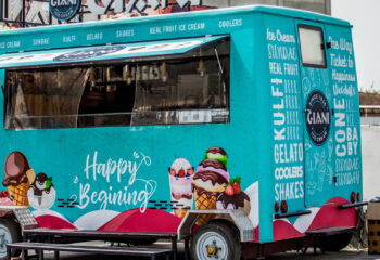 a teal food truck selling ice cream parked without an attendant