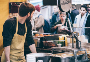 food truck server looking at a number of customers in front of the food truck