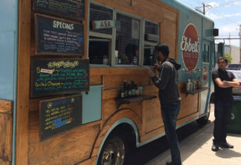 wood style food truck with blue accents offering different kinds of food