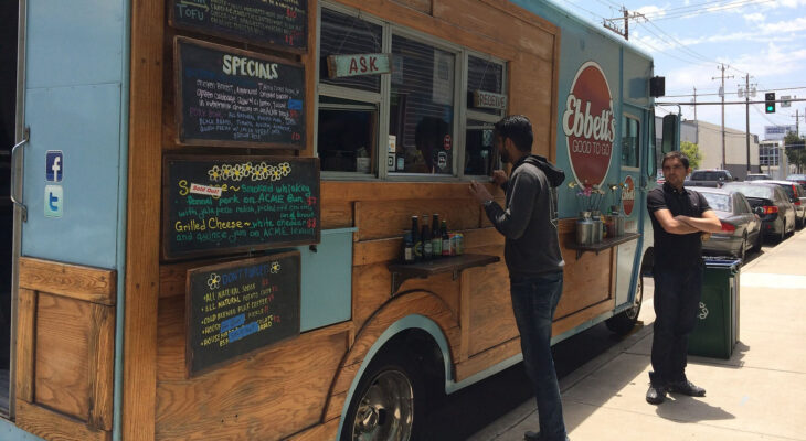 wood style food truck with blue accents offering different kinds of food