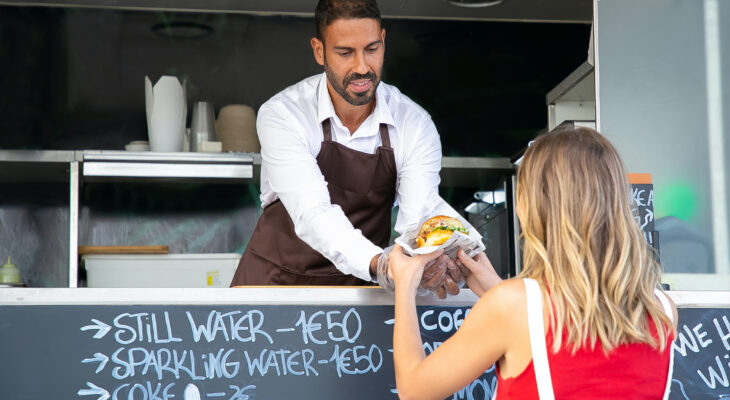 food truck customer receiving a burger from a food truck burger