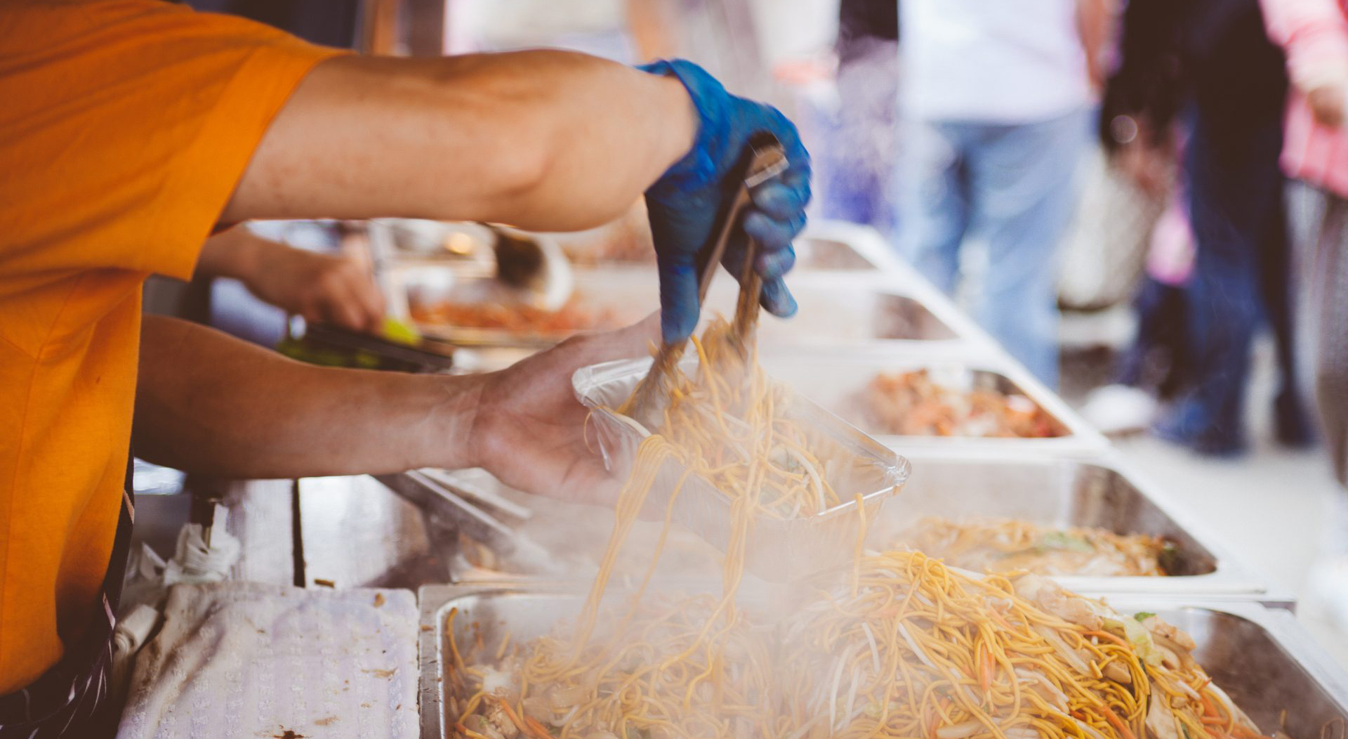 food truck server preparing noodles for a customer