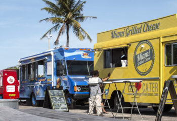 food truck businesses lined up on a street selling drinks and sandwiches