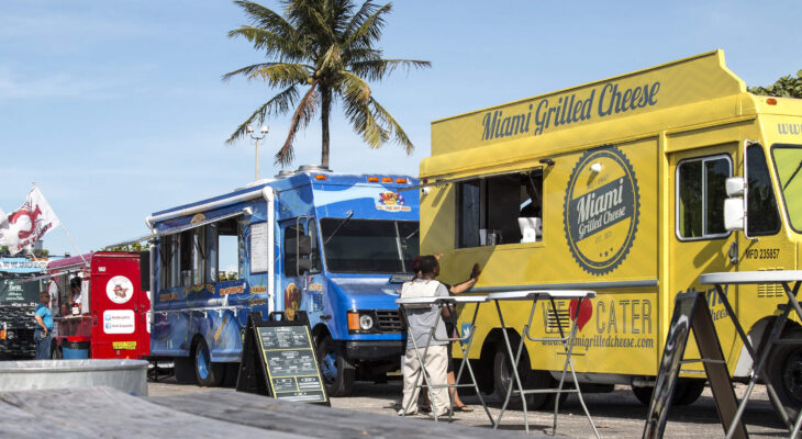 food truck businesses lined up on a street selling drinks and sandwiches