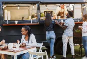 group of people ordering and eating food from a food truck